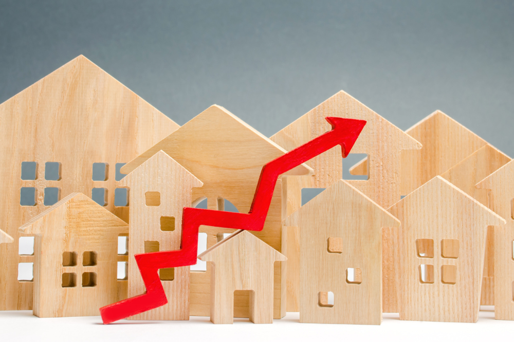 Petites maisons en bois avec une courbe représentant l'inflation