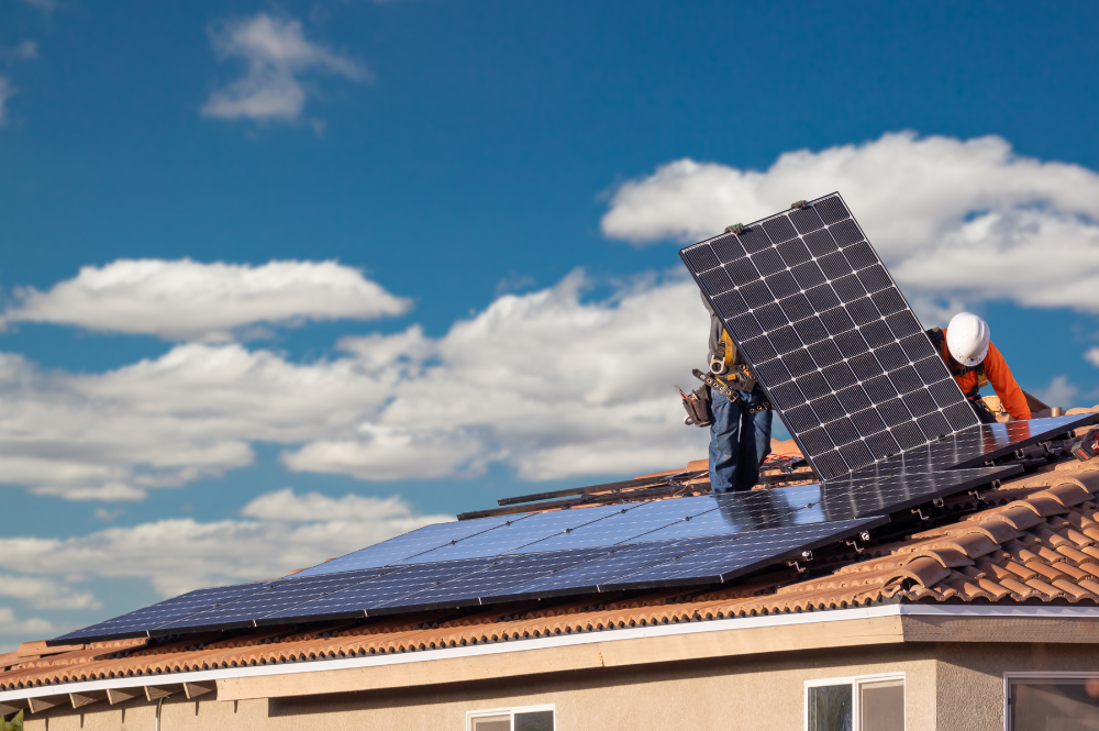 Personnes en train d'installer des panneaux photovoltaïques sur le toit d'une maison