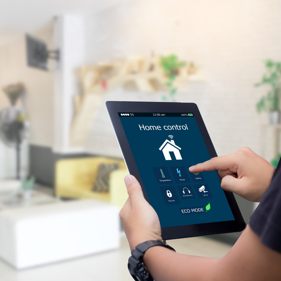 Une personne tient une tablette dans sa main pour contrôler sa maison