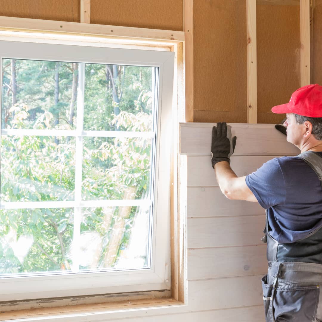 Un artisan est en train d'isoler les murs d'une maison